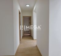 Ein Flur mit weißen Wänden und einem Boden in Holzoptik in einer Zweizimmerwohnung.