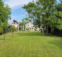 Der Garten beim Einfamilienhaus in Lackovce mit gepflegtem Rasen und Bäumen.