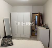 Helles Schlafzimmer in einem Einfamilienhaus mit weißen Möbeln und einem an die Wand gelehnten Spiegel.
