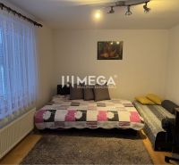 Ein Zimmer mit Betten und einem Tisch in einem Einfamilienhaus, Boden mit Holzdekor.