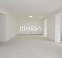 Ein weißer leerer Raum mit Betonboden in einer 3-Zimmer-Wohnung.