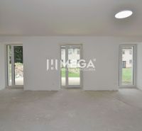 Ein geräumiges Zimmer in einer 3-Zimmer-Wohnung mit großen Fenstern und Blick in den Garten.