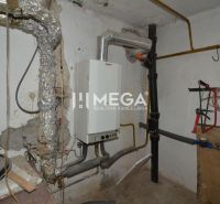 Heizraum in einem Einfamilienhaus mit einem Rohrsystem und einem Wasserspeicher.