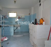 Ein Abstellraum in einem Einfamilienhaus mit blauen Fliesen und einfacher Einrichtung.