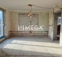 Ein unmöbliertes Zimmer in einem Einfamilienhaus mit Betonboden und Balkontüren.