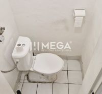 Toilette im Büro mit weißen Wänden und Keramikboden.