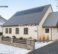 Ein Haus mit einem schrägen Dach und Holzverkleidung im winterlichen Zboj, Geschäftsräume.