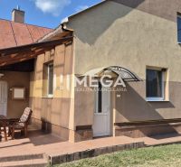 Ein Einfamilienhaus in Krásny Brod mit überdachter Terrasse und Gartenmöbeln.