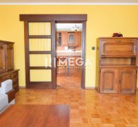 Wohnzimmer in einem Einfamilienhaus mit Holzmöbeln und einem Boden in Holzoptik.