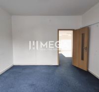 Geschäftsräume mit blauem Teppichboden und heller Wand, geschlossene Holztür.