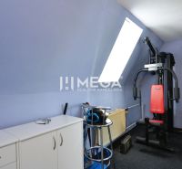 Ein Zimmer in einem Einfamilienhaus mit Sportgeräten und Möbeln.