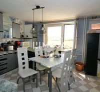 Eine Küche in einem Einfamilienhaus mit Essecke, helle Wände und moderne Beleuchtung.