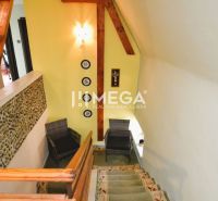 Treppe eines Einfamilienhauses mit Holzverkleidung und Steindekoration an der Wand.