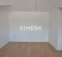 Ein Zimmer in einer 2-Zimmer-Wohnung mit einem Boden in Holzoptik und weißen Wänden.