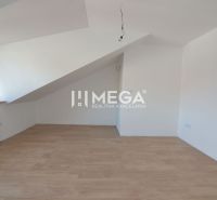 Dachgeschosszimmer mit Holzboden in einer 2-Zimmer-Wohnung.