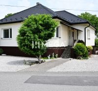 Ein Einfamilienhaus in Udavské mit einem gepflegten Garten, einem Gehweg und Ziersträuchern.