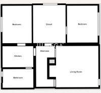 Grundriss eines Einfamilienhauses mit zwei Schlafzimmern, Wohnzimmer, Küche und Badezimmer.