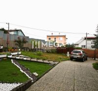 Der Garten eines Einfamilienhauses im Wohngebiet Poľana in Humenné mit Autos und Grünflächen.
