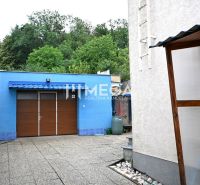 Einfamilienhaus im Wohngebiet Poľana in Humenné mit blauer Garage und gepflastertem Hof.