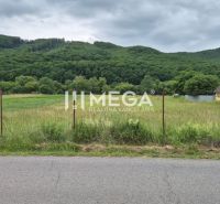 Grundstücke - Wohnen in Zubné, grüne Wiesen, Umzäunung, Auto an der Straße, bewaldete Hügel.