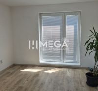 Ein Büro mit einer Pflanze, einem Holzboden und Balkontüren mit Jalousien.