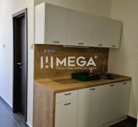 Küchenecke im Büro mit Holzdekor und großem Fenster.