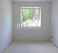 Ein leerer Raum in einem Einfamilienhaus mit weißen Wänden und einem Fenster.
