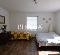 Schlafzimmer im Einfamilienhaus mit Bett, Schrank und Boden mit Holzdekor.