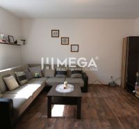 Wohnzimmer mit Sofa, Tisch und Holzboden in einem Einfamilienhaus.