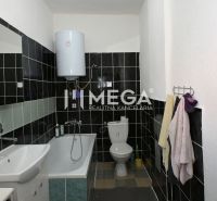 Badezimmer in einem Einfamilienhaus mit Badewanne, Waschbecken und Kessel, schwarz-weiße Fliesen.