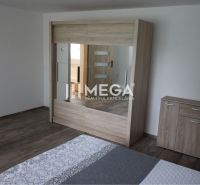 Schlafzimmer mit einem Spiegelschrank und einer Kommode in einem Einfamilienhaus mit einem Boden in Holzoptik.