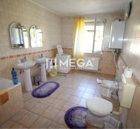 Ein Badezimmer im Einfamilienhaus mit zwei Waschbecken, einer Badewanne und einer Waschmaschine.