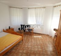 Schlafzimmer mit Holzmöbeln und Fliesen in einem Einfamilienhaus.
