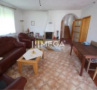 Wohnzimmer eines Einfamilienhauses mit Kamin, Ledermöbeln und Fliesenboden.