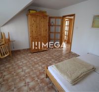 Ein Schlafzimmer in einem Einfamilienhaus mit Holzmöbeln und Fliesen.