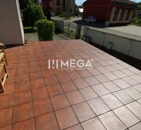 Die Terrasse des Einfamilienhauses in Pčoliné in der Straße Pčoliné mit Ziegelpflaster und einer Holzbank.