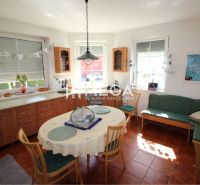 Esszimmer in einem Einfamilienhaus mit rundem Tisch, Stühlen, Sofa und Dekorationen.