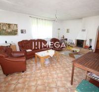 Wohnzimmer in einem Einfamilienhaus mit Kamin, Ledersofa und Bildern an den Wänden.