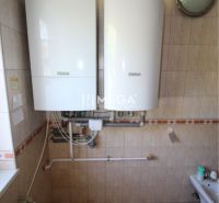 Badezimmer im Einfamilienhaus mit Vaillant-Gasthermen und Fliesen an der Wand.