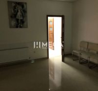 Das Innere eines Gebäudes mit weißen Stühlen, einem Bild und einer offenen Tür mit einem Verifizierungsaufkleber.
