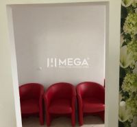 Drei rote Sessel mit weißen Wänden und einer Blumen-Tapete in einem Gebäude.
