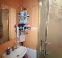 Badezimmer in einer 2-Zimmer-Wohnung mit orangefarbenen Fliesen und Duschkabine.