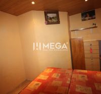 Schlafzimmer mit Bett, Kommode und Boden mit Holzdekor in einer 3-Zimmer-Wohnung.