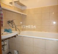 Badezimmer in einer 3-Zimmer-Wohnung mit Badewanne und Fliesen in Beigetönen.