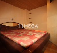 Schlafzimmer in einer 3-Zimmer-Wohnung mit einem großen Bett und einem Boden in Holzoptik.