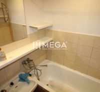 Badezimmer mit Fliesen, Badewanne und Waschbecken in einer 3-Zimmer-Wohnung.