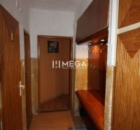 Der Flur in der 3-Zimmer-Wohnung mit einem Boden in Holzoptik und Holzmöbeln.