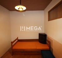 Ein Zimmer mit einem Bett und einem Nachttisch in einer 3-Zimmer-Wohnung mit Holzboden.