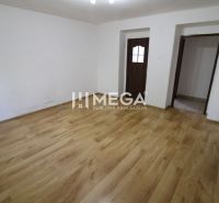 Ein Zimmer in einer 3-Zimmer-Wohnung mit einem Boden in Holzoptik und weißen Wänden.