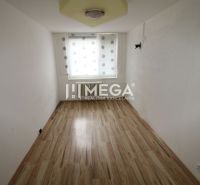 Ein schmaler Raum mit einem Fenster und einem Boden in Holzoptik in einer 3-Zimmer-Wohnung.